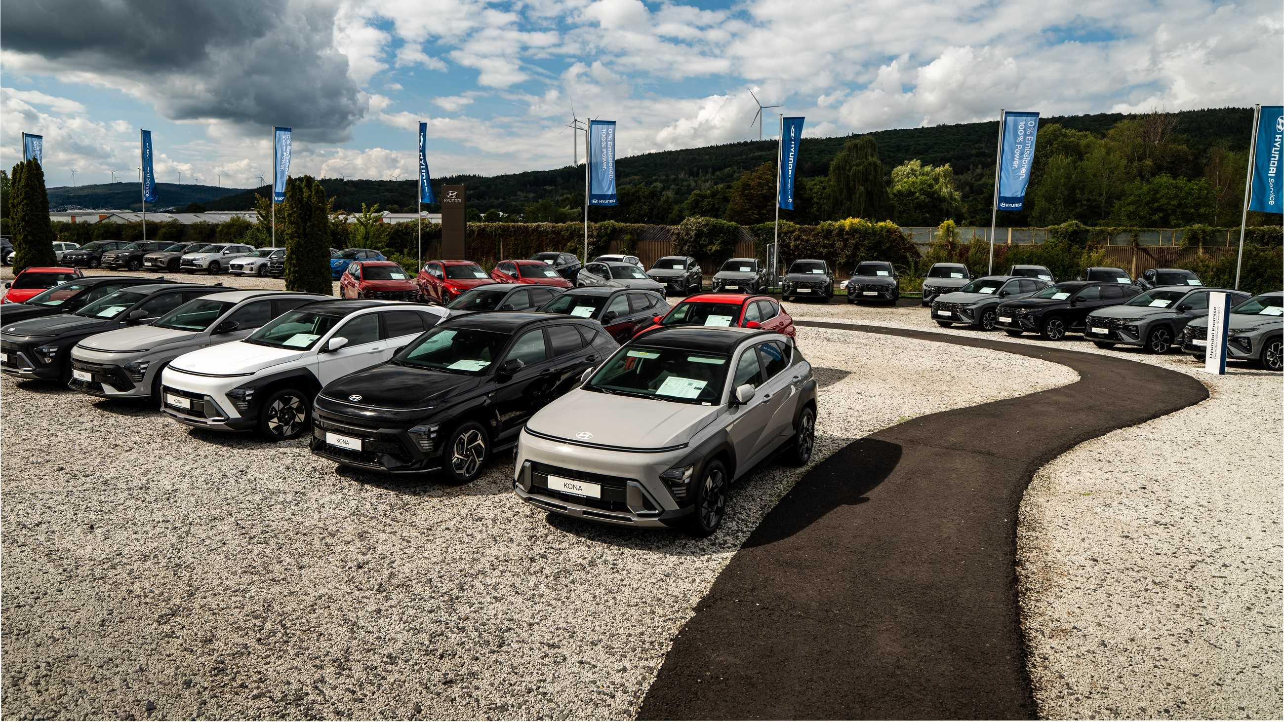 Fahrzeughof mit Hyundai-Fahnen, geschwungener Weg zwischen den Fahrzeugreihen