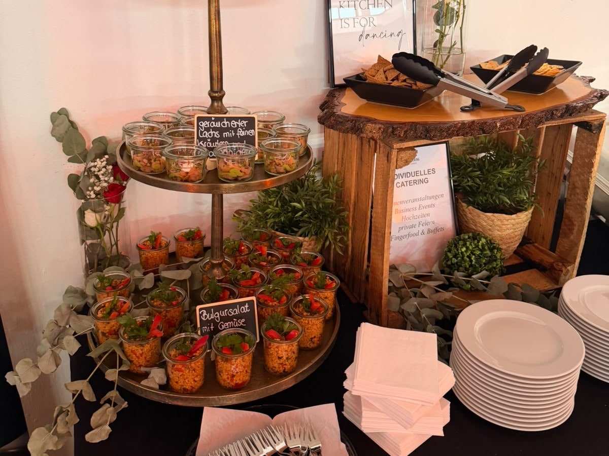 Buffet von Millers Catering: Etagere mit Salaten im Glas, daneben Holzkisten, Teller und Servietten