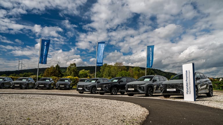 Der Hof mit Hyundai-Pylon und Fahrzeugreihe unter einem Wolkenhimmel
