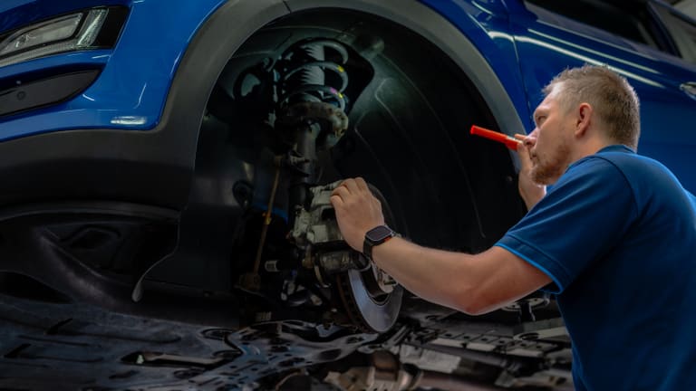 Mechaniker prüft die Vorderradbremse eines Hyundai in der Werkstatt
