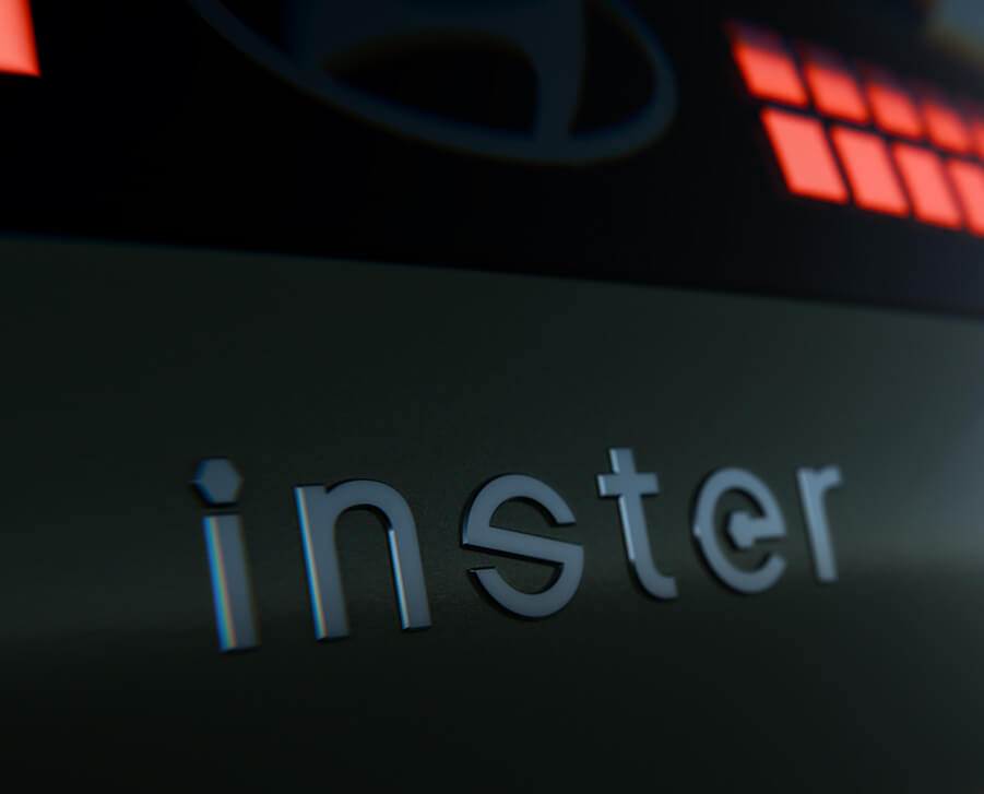 Nahaufnahme des Wortes „inster“ in metallischen Buchstaben auf einer dunklen Oberfläche, mit rot beleuchteten Quadraten und einem Teil eines Logos im Hintergrund.